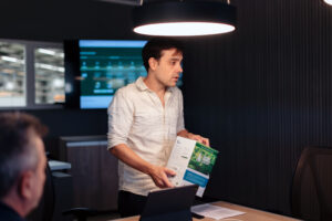 Matías Imperiale, cofundador de Agro Sustentable, expone productos ecológicos para cultivos en una presentación técnica en oficina.