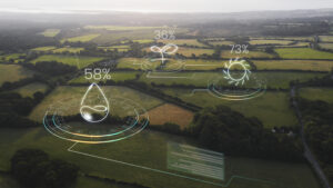 Vista aérea de campos agrícolas con gráficos digitales superpuestos que muestran datos de humedad, crecimiento vegetal y radiación solar como parte de un sistema de agricultura inteligente.